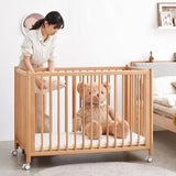 Scandinavian beech wood bed side baby crib with wheels ember primary product view.