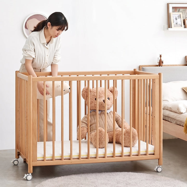 Scandinavian beech wood bed side baby crib with wheels ember primary product view.