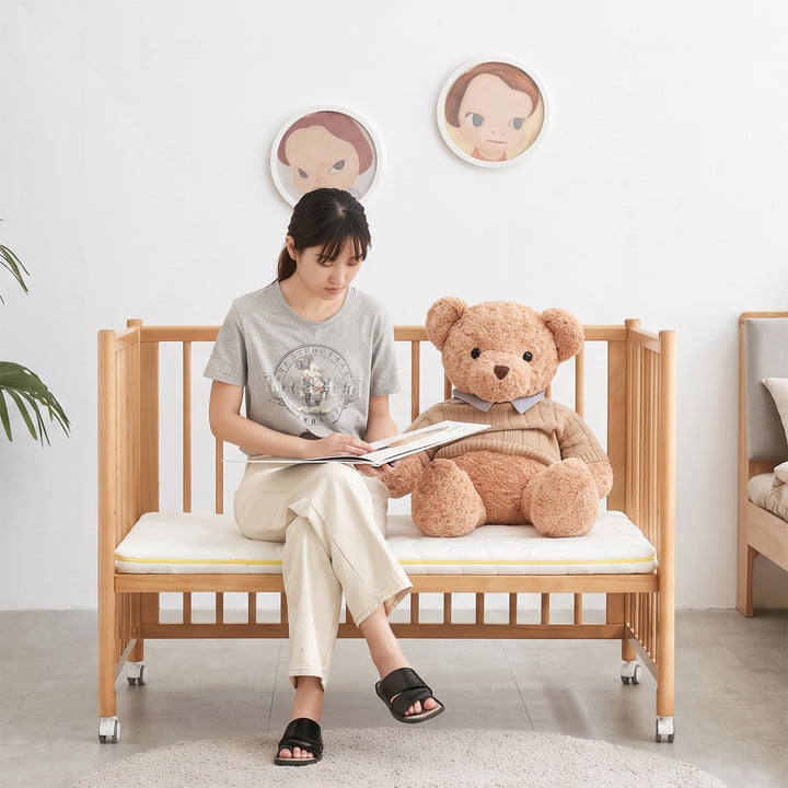 Scandinavian beech wood bed side baby crib with wheels ember material variants.