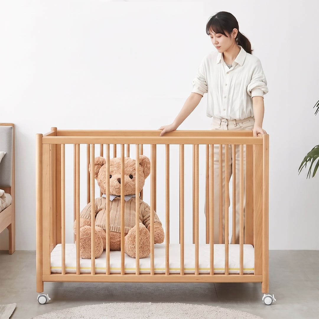 Scandinavian beech wood bed side baby crib with wheels ember in real life style.