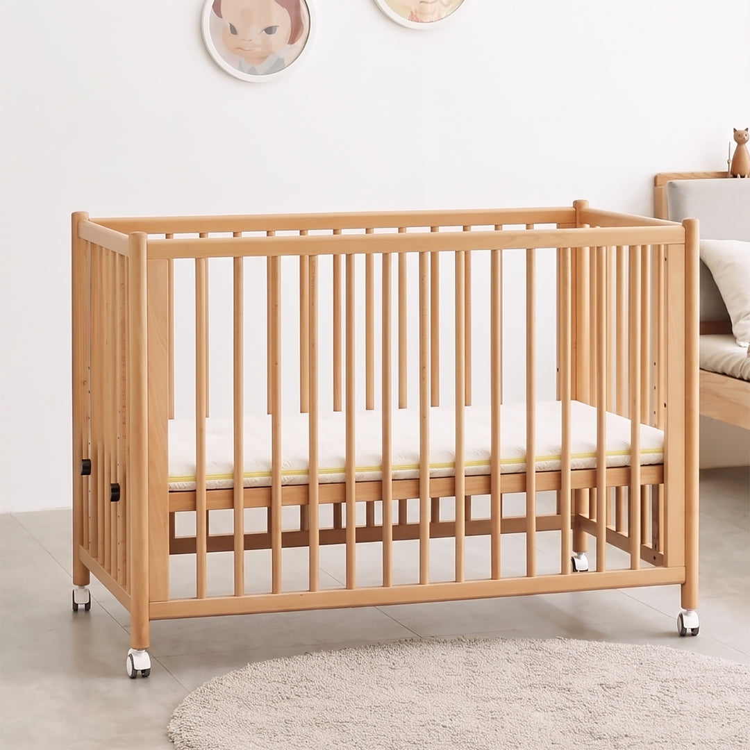 Scandinavian beech wood bed side baby crib with wheels ember with context.