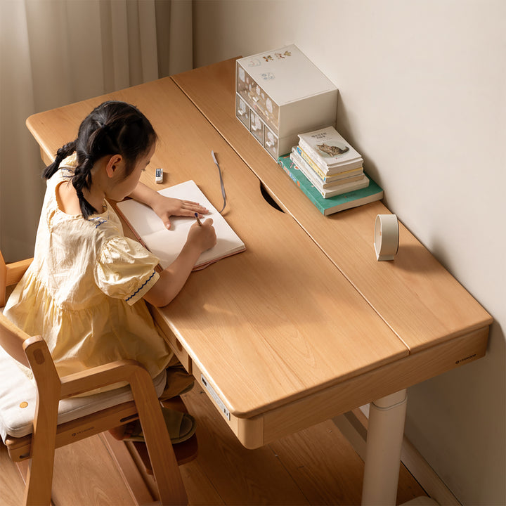 Scandinavian beech wood electric height adjustable kids study table with intergrated led light orbita in real life style.