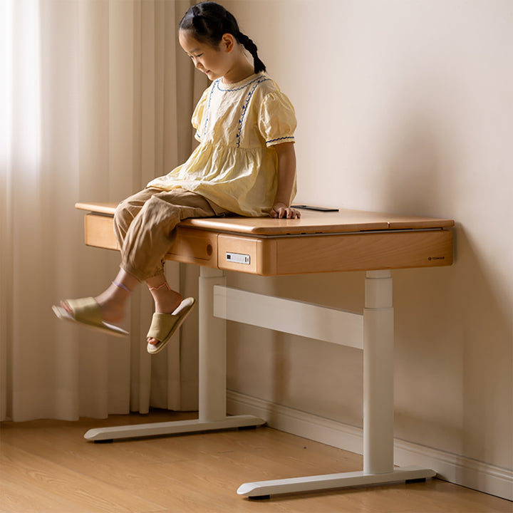 Scandinavian beech wood electric height adjustable kids study table with intergrated led light orbita in panoramic view.