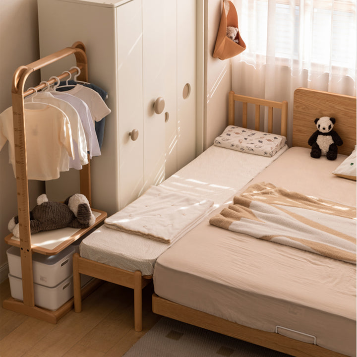 Scandinavian beech wood height adjustable kids sidecar bed with mattress anchor in close up details.