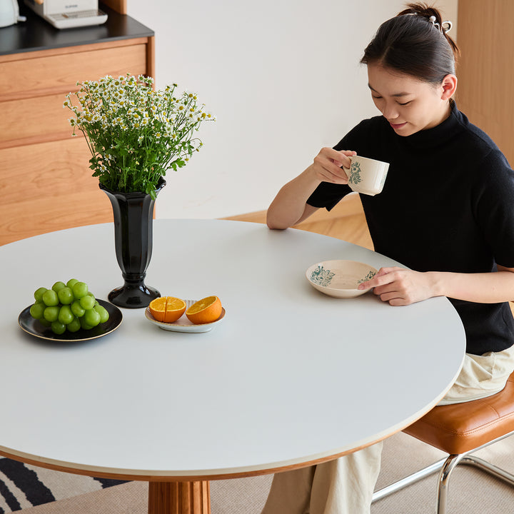 Scandinavian cherry wood sintered stone round dining table grey in real life style.