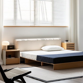 Modern bedroom with a bed, nightstands, and a chair.