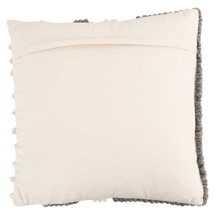 Versatile hand-woven wool looped pillow with context.