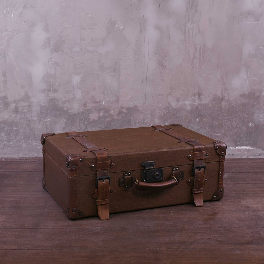 Vintage canvas and genuine leather side table suitcase trunk 1920s in still life.