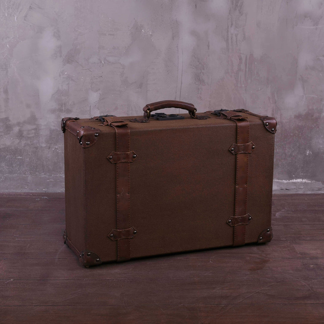 Vintage canvas and genuine leather side table suitcase trunk 1920s in panoramic view.